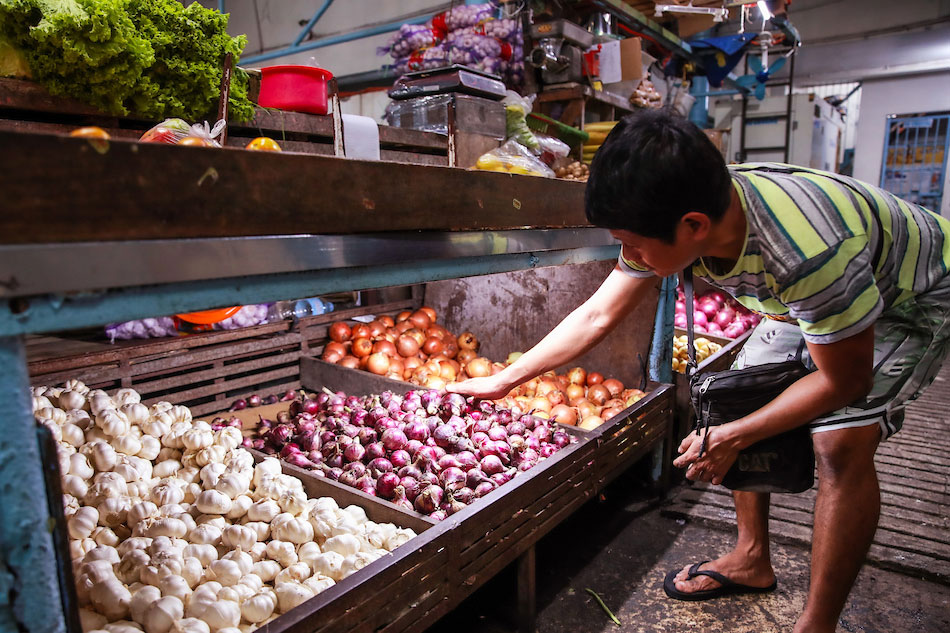 A produce vendor attends to the store’s inventory of both local and imported onions at a public market in Marikina City on January 25, 2023. Jonathan Cellona, ABS-CBN News