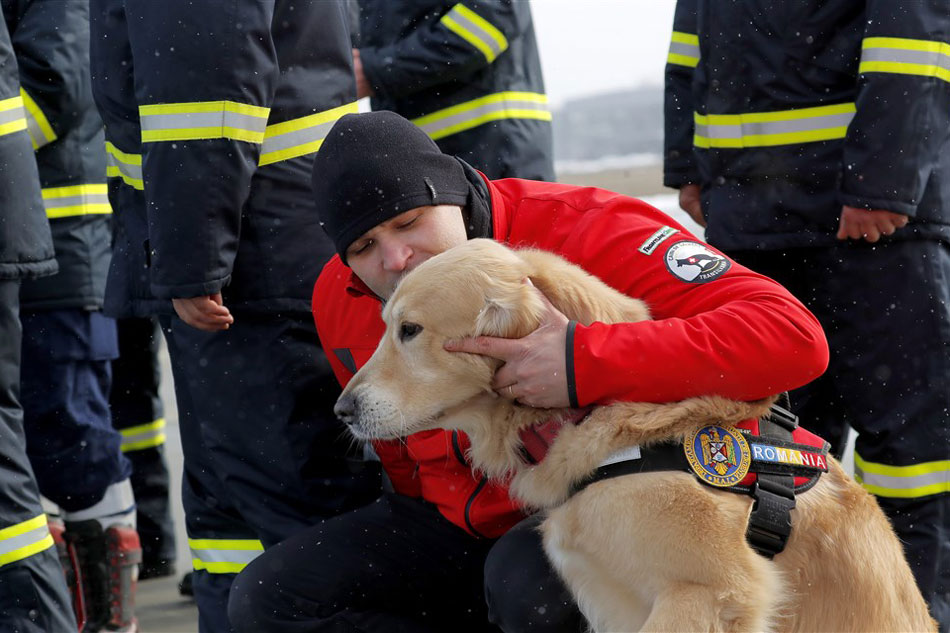 A Romanian rescue worker caresses his sniffing rescue dog during a last briefing held on the runaway, before to be deployed to Southern Turkey to help local authorities in their rescue missions after the devastating earthquake that hit Turkey and Syria, at the military airbase no. 90, in Otopeni, near Bucharest, Romania, Feb. 8, 2023. Robert Ghement, EPA-EFE 