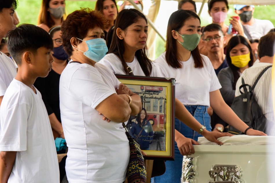Irish Nicole Abulad holds a photograph of her mother, Wilma Tezcan during her burial on February 18, 2023 at Heaven's Garden Memorial Park in Tayabas City, Quezon. Tezcan died in the earthquake that hit Turkey on February 6 which left thousands dead and injured. Maria Tan, ABS-CBN News