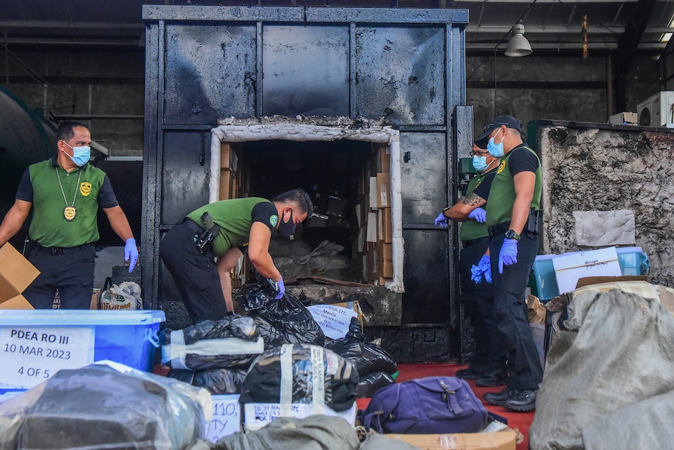 Agents from the Philippine Drug Enforcement Agency (PDEA) and workers load confiscated illegal drugs into an incinerator during the destruction of narcotics in Trece Martires, Cavite on March 16, 2023. Maria Tan, ABS-CBN News