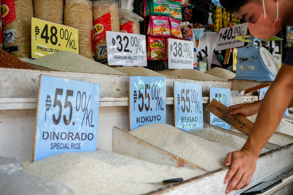 A market vendor waits for customers in front of their rice and grains store inside public market in Quezon City on July 19, 2022. George Calvelo, ABS-CBN News
