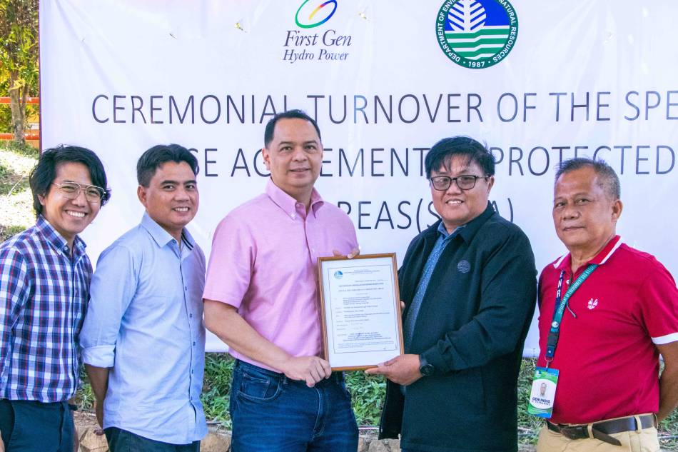 Joselito Blanco (second from right), protected area superintendent and DENR assistant regional technical director, hands to Dennis Gonzales (center), First Gen senior vice president, a plaque containing the covering page of the special agreement between the DENR and FGHPC allowing the First Gen subsidiary to pursue the development of a 120-megawatt pumped storage hydroelectric facility in Pantabangan, Nueva Ecija, while preserving the status of the project site as part of a protected area. Also in photo are (from left) Andre Torres, First Gen manager and deputy project lead; Ferdimar Biscocho, First Gen assistant vice president and project lead; and Gerundio Fernandez, Nueva Ecija provincial environment and natural resources officer. Handout