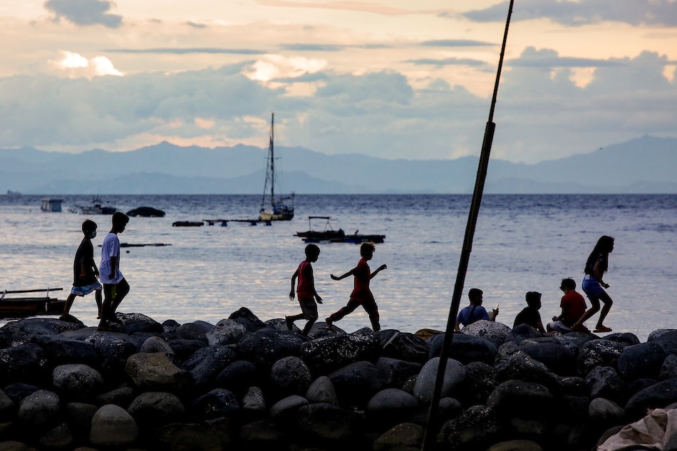 Children spend time at the breakwater near a fishing village in Davao City on May 10, 2022. George Calvelo, ABS-CBN News