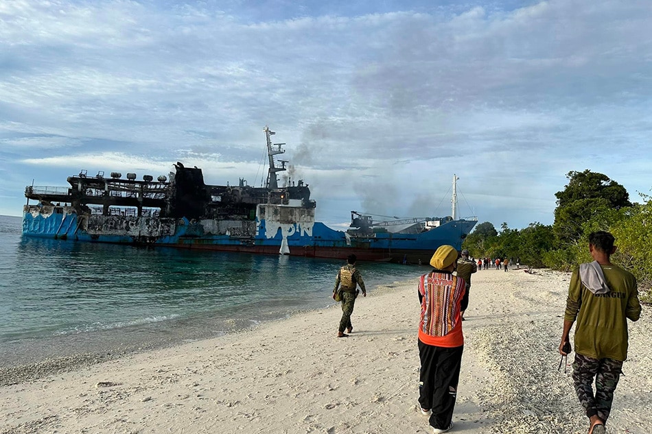 Authorities check the remains of MV Lady Mary Joy 3 at the shore of Baluk-Baluk Island, hours after it caught a fire that killed at least 12 people. Philippine Coast Guard/Facebook