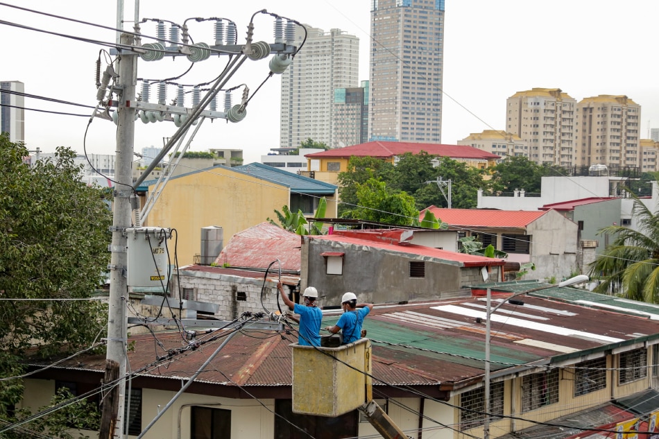 Linemen work on electrical posts at a street in Mandaluyong on September 15, 2021. George Calvelo, ABS-CBN News/File