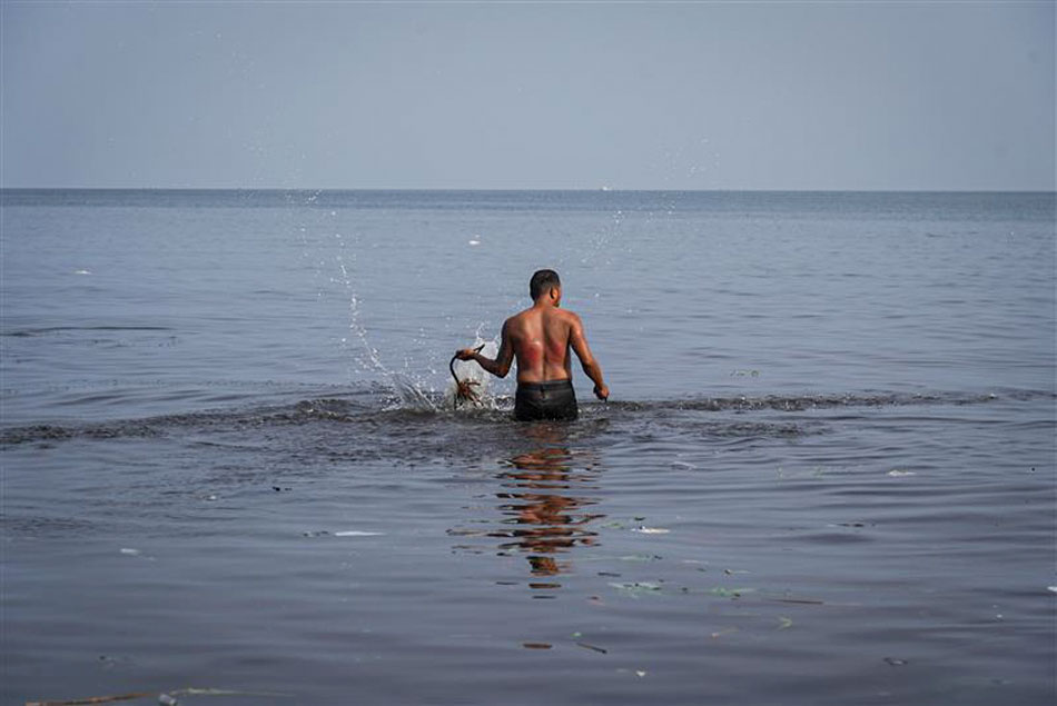 A penitent washes his wounds in Manila Bay after performing self-flagellation as a form of penance and to atone for his sins in Brgy. Ligtong, Rosario, Cavite on Good Friday, 07 April 2023. Larry Monserate Piojo, ABS-CBN News
