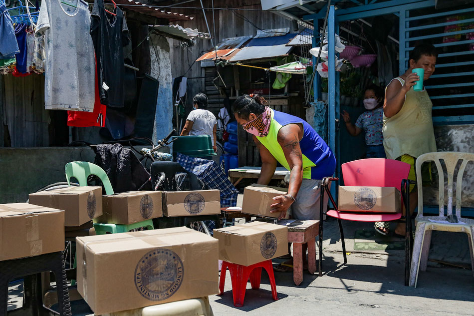 Residents get food boxes they received from the local government inside a locked down community in Barangay Tunasan, Muntinlupa City on August 14, 2021. George Calvelo, ABS-CBN News