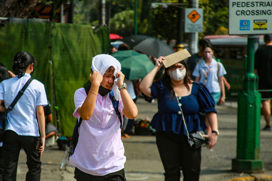People shield themselves from the sun as they walk toward a transport terminal in Manila on April 17, 2023. Jonathan Cellona, ABS-CBN News/File