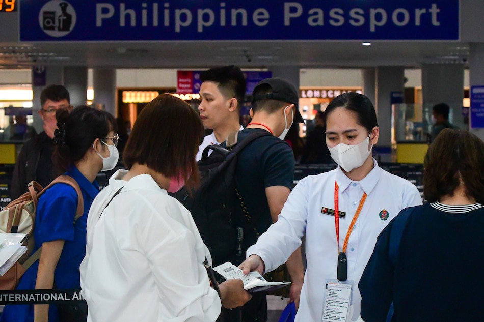 Security before the immigration counters check international passengers' passport and boarding pass at the Ninoy Aquino International Airport Terminal 3 in Pasay City on April 24, 2023. The Manila International Airport Authority plans to implement RFID passes for airport workers in light of alleged airline personnel involved in human trafficking according to the Bureau of Immigration. Mark Demayo, ABS-CBN News 