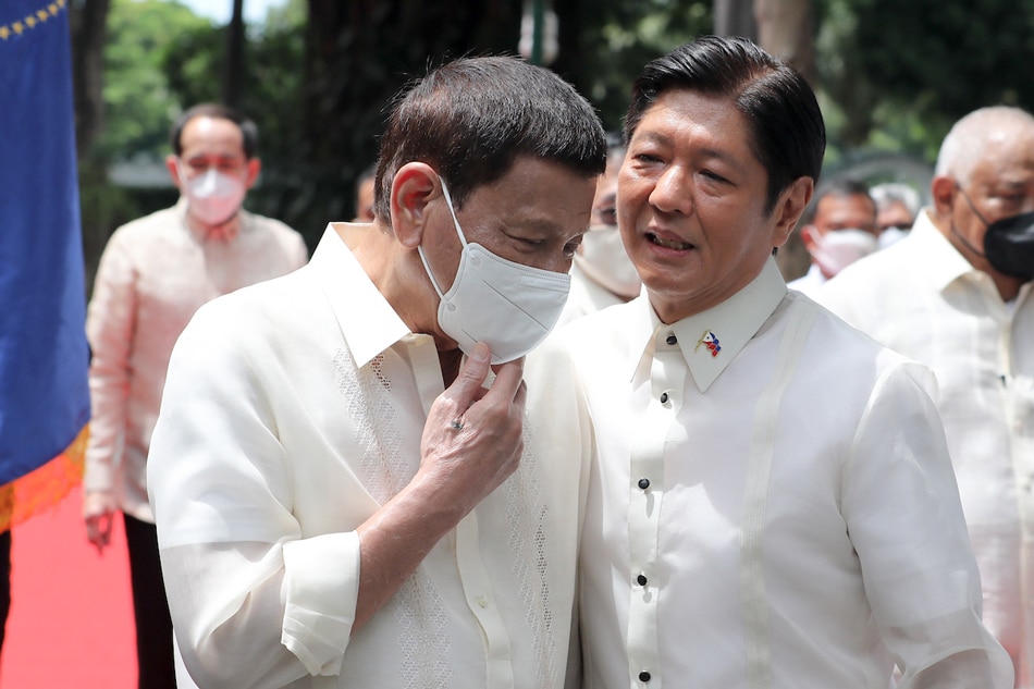 Outgoing Philippine President Rodrigo Duterte (left) speaks to his successor Ferdinand Marcos, Jr. (right) after the departure honors for Duterte at the Malacañang Palace in Manila on June 30, 2022. Arman Baylon, Presidential Photo