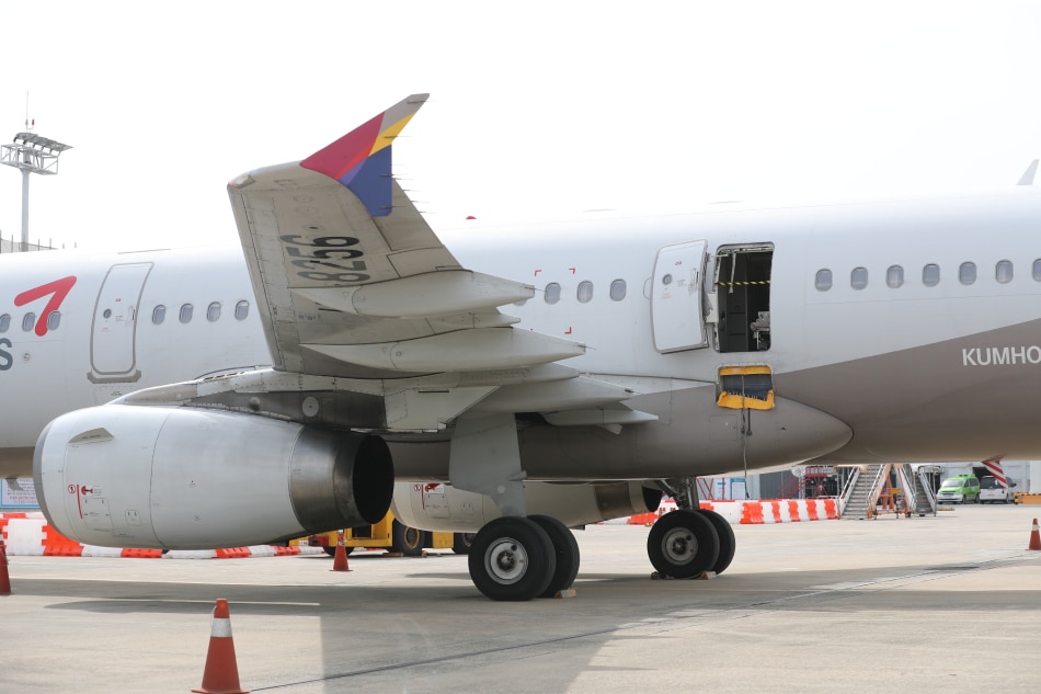 An Asiana Airlines plane is parked after an emergency landing at Daegu International Airport, 237 kilometers southeast of Seoul, South Korea, 26 May 2023, with its door left open. Yonhap South Korea/EPA-EFE.