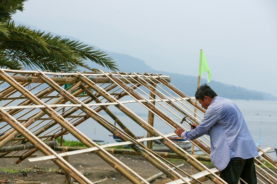 A carpenter fastens bamboo poles as support for the roof of a bahay kubo in Laurel, Batangas on June 30, 2021. File/Jonathan Cellona, ABS-CBN News