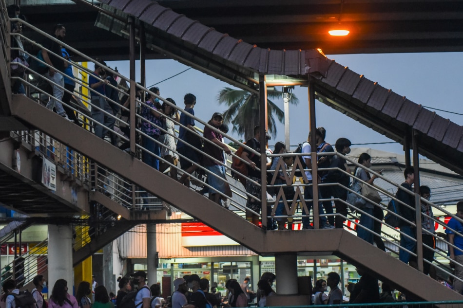 Commuters caught in the afternoon downpour wait in line for public transport while traffic builds up in Quezon City on May 25, 2023 as super typhoon Mawar nears the Philippine area of responsibility. Maria Tan, ABS-CBN News/File