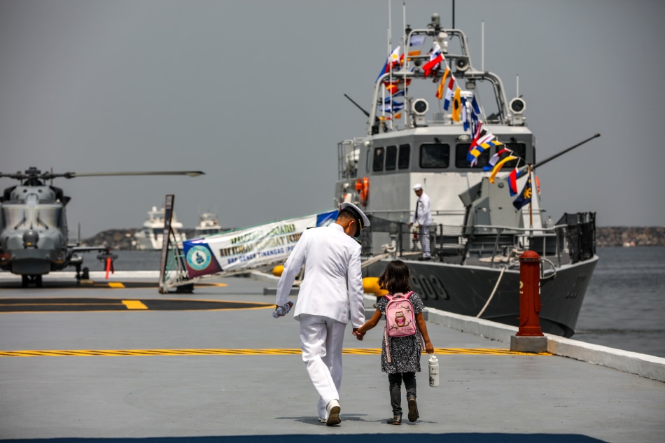 A Navy officer accompanies a young guest after the formal ceremonies for the 125th founding anniversary of the Philippine Navy was held at the Navy Headquarters on Roxas Boulevard in Manila on May 26, 2023. Jonathan Cellona, ABS-CBN News