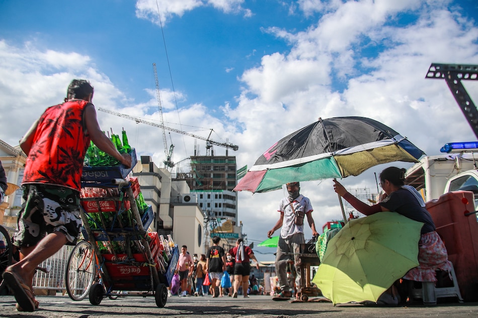 People use umbrellas to shield themselves from the sun as they continue their activities at Plaza Miranda in Manila on May 5, 2023. Jonathan Cellona, ABS-CBN News/File