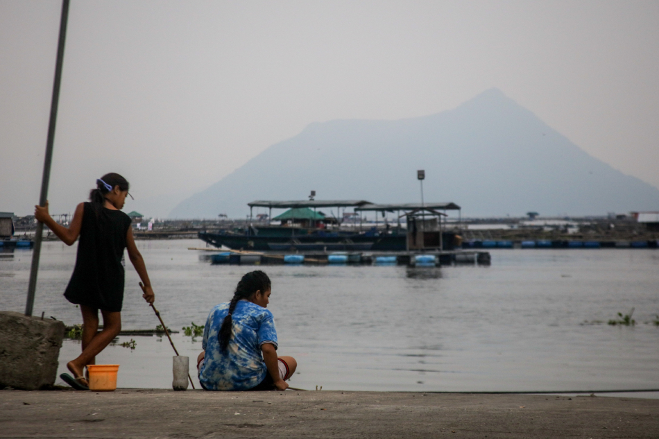 Fisherfolk continue with their work during a cloudy afternoon in Laurel Batangas on June 7, 2023. Local government officials advised residents near the lake to take precautions for possible emissions of volcanic smog from the Taal volcano. Jonathan Cellona, ABS-CBN News