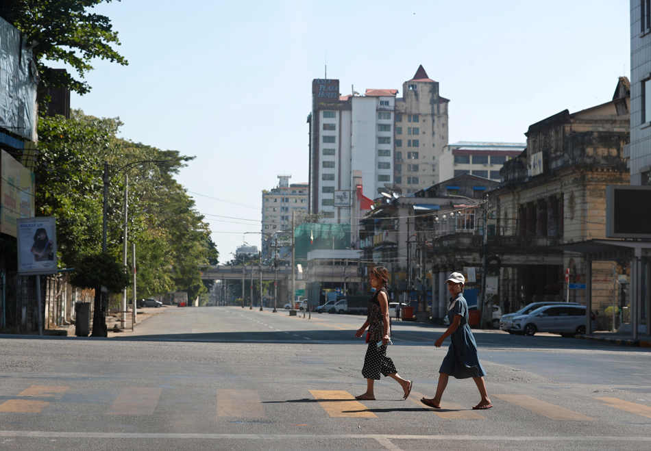 Girls cross the empty street in downtown Yangon, Myanmar on Dec. 10, 2021. Anti-coup groups call for the public to participate the Silent Strike to protest against the military coup, by staying at home and to shut down businesses from 10 a.m. to 4 p.m. on Dec. 10, 2021. EPA-EFE/Stringer