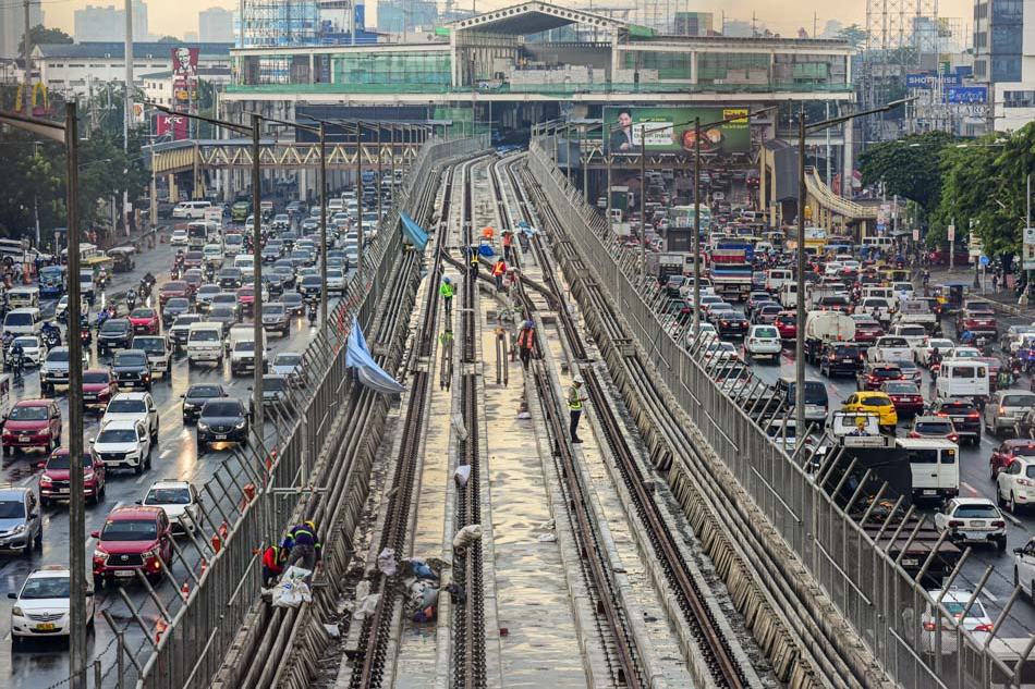 Train track engineers and laborers continue working on the Metro Rail Transit 7 along Commonwealth Avenue in Quezon City on July 8, 2023, after a brief respite from the heat due to the sudden downpour in parts of the city. Maria Tan, ABS-CBN News
