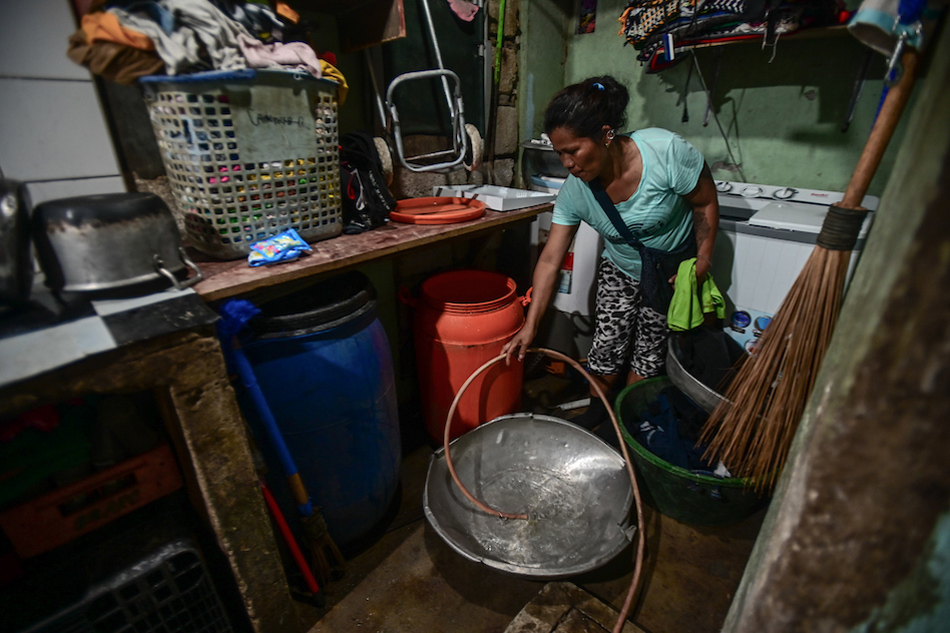  Suzette Brasero, 43, a resident of Bgy. Manresa fills water containers ahead of a nine-hour water interruption scheduled for July 12, 2023. More than 500,000 Maynilad customers will be affected by the interruption because of the low water level in Angat Dam, which has fallen below the minimum operating level of 180 meters above sea level. Maria Tan, ABS-CBN News