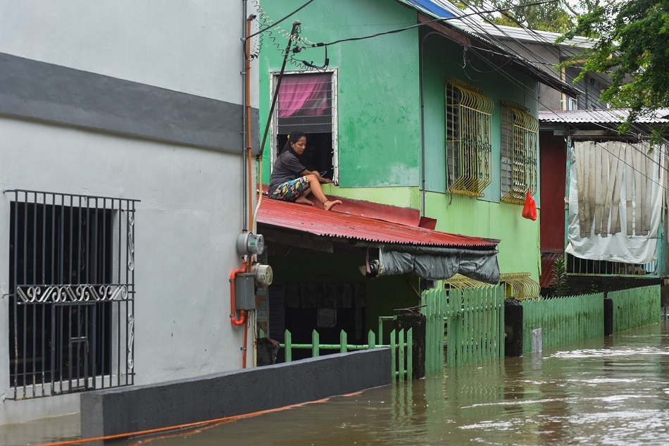 Residents of Barangay San Miguel in Calumpit, Bulacan sit on the roof of their houses as the flood in their community reach neck-deep on July 31, 2023 due to continuous rains for days. Maria Tan, ABS-CBN News