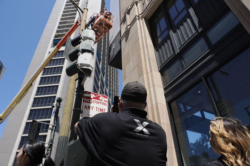 A person with NeXgen Facilities Group (not affiliated with X.com), a commerical cleaning service, looks up at the workers moving closer to clean the vertical Twitter sign after all signage pertaining to Twitter was removed after the owner of the company, Elon Musk, annouced the rebranding of the social media platform and replacing its iconic bird logo with an X at the company’s headquarters in San Francisco, California, USA, 31 July 2023. EPA-EFE/JOHN G. MABANGLO