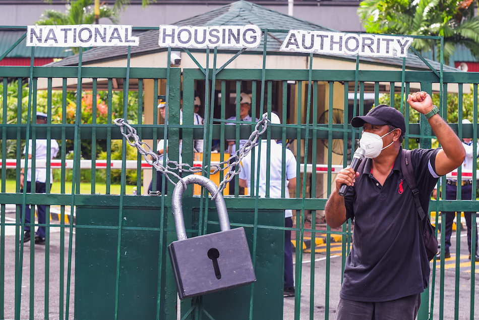 Representatives of different urban poor communities displaced from National Housing Authority (NHA) relocation sites symbolically lock down the NHA main office at Elliptical Road in Quezon City on August 8, 2023. Maria Tan, ABS-CBN News