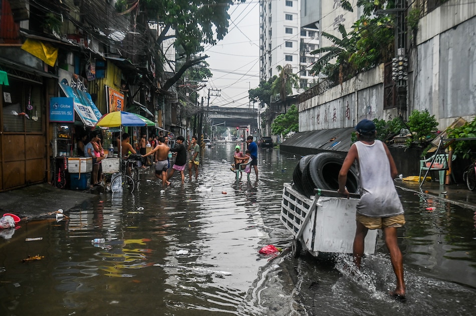People cross flood waters brought by localized thunderstorms along Araneta Avenue in Quezon City on June 6, 2023. Maria Tan, ABS-CBN News/File