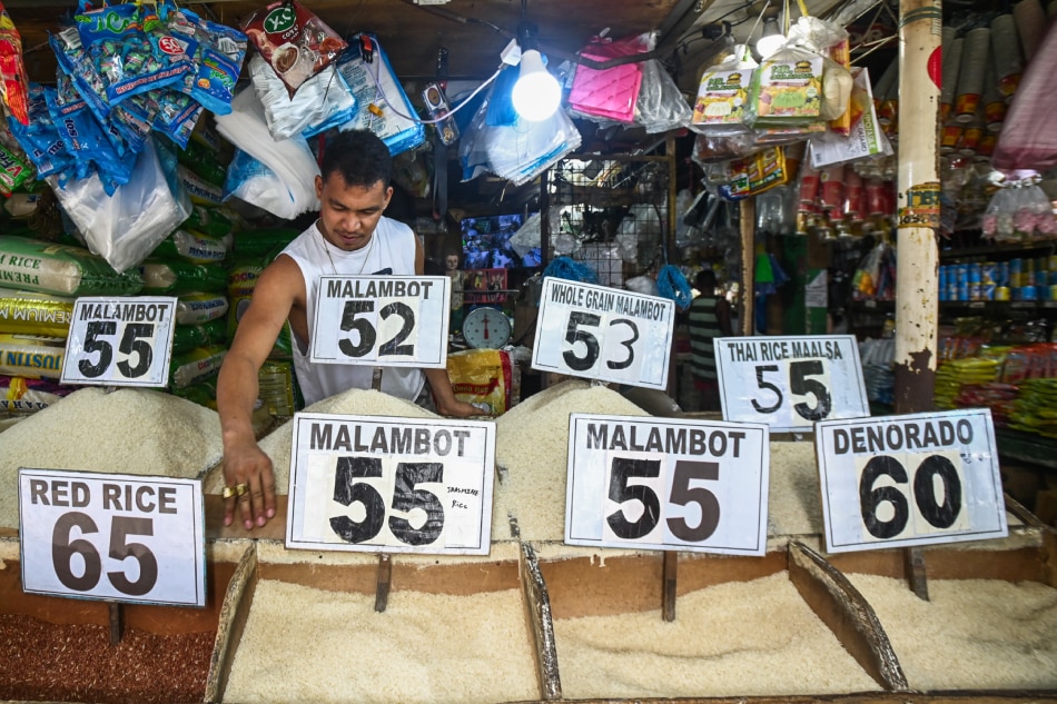 A worker from a rice dealer in Mega Q-Mart in Cubao, Quezon City, arranges the store's supply of different rice varieties, including 'Denorado' rice, which is marked with a P60 price tag on Tuesday, August 22, 2023. Maria Tan, ABS-CBN News