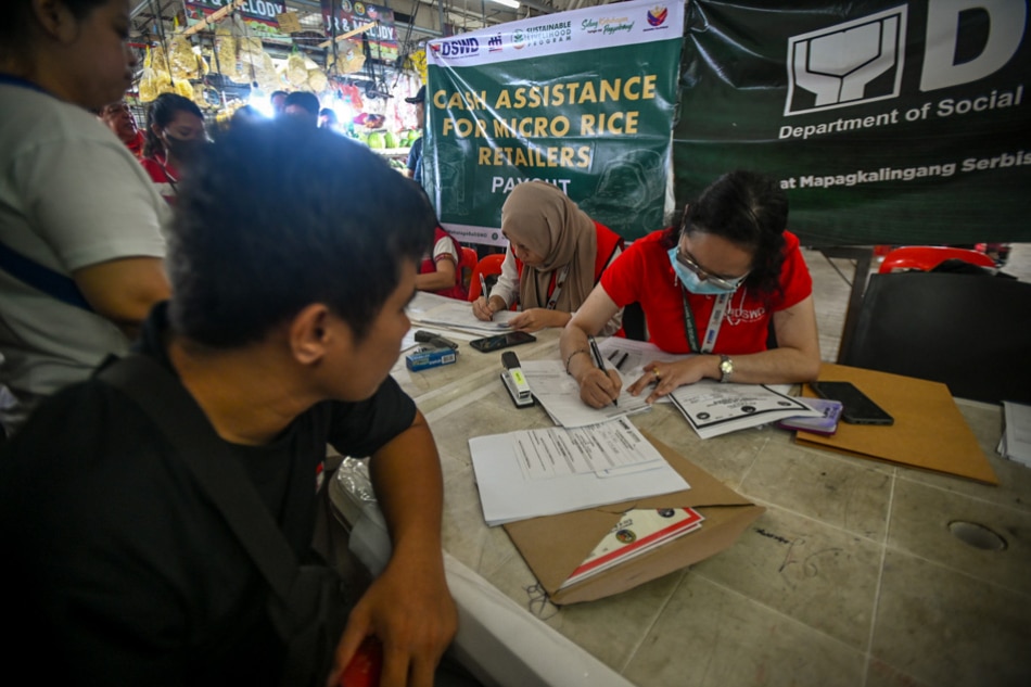 Representatives from the Department of Trade and Industry, Department of Social Welfare and Development, Department of Agriculture and the city government of San Juan distribute cash aids to rice retailers affected by Executive Order 39, which sets price ceilings on rice, at the Agora Market on Sept. 9, 2023. ABS-CBN News/Maria Tan