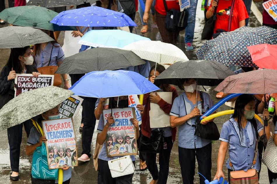 Hundreds of teachers from various schools brave the rain as they hold a unity march towards Mendiola, Manila on October 5, 2023 to mark World Teachers