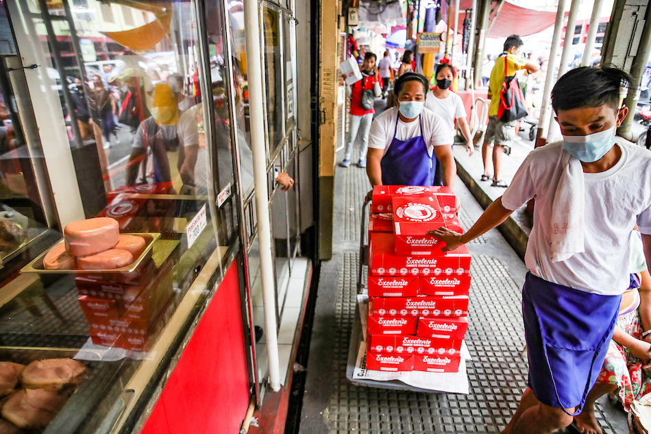 Store attendants push a cart full of packaged ham at the Excelente Ham Chinese Cooked Ham in Quiapo Manila on December 9, 2022. Ham products, a Noche Buena staple, are sold between P750 to P3,000. Jonathan Cellona, ABS-CBN News