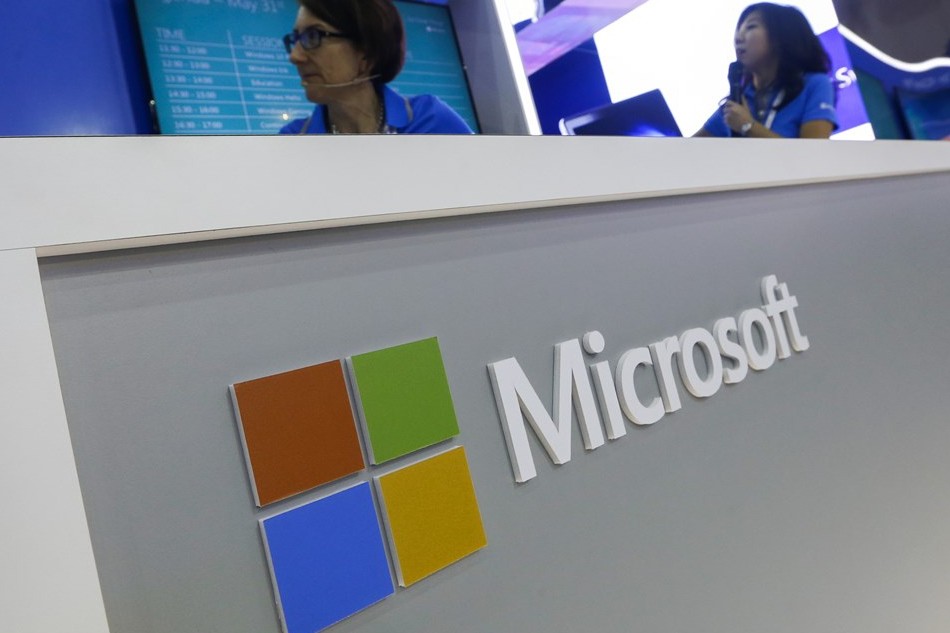 Exhibitors stand next to the Microsoft logo during the COMPUTEX, the largest computer show in Asia, in Taipei, Taiwan, 31 May 2016. EPA/RITCHIE B. TONGO/FILE
