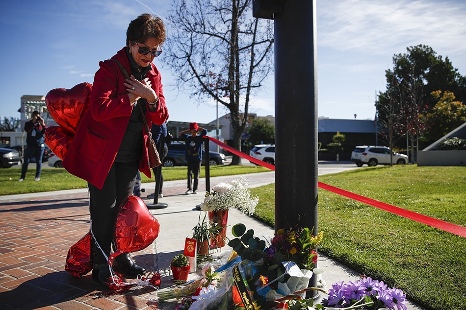 Josephina Guzman says prayers at a makeshift memorial outside of Monterey Park City Hall in Monterey Park, California, USA, Jan. 23, 2023. A 72-year-old man of Asian descent shot and killed 10 people as they celebrated the Lunar New Year at Star Dance Studio on Jan. 21, 2023. Caroline Brehman, EPA-EFE 