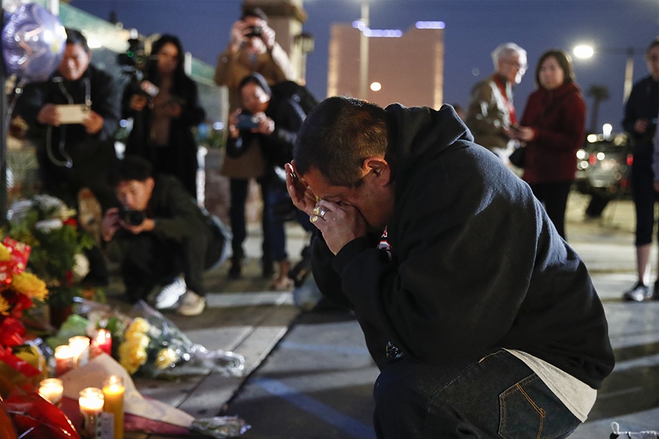 A person kneels down in front of a makeshift memorial outside of Star Dance Studio in Monterey Park, California, USA, 23 January 2023. A 72-year-old man of Asian descent shot and killed 10 people as they celebrated the Lunar New Year at Star Dance Studio on 21 January 2023. EPA-EFE/CAROLINE BREHMAN