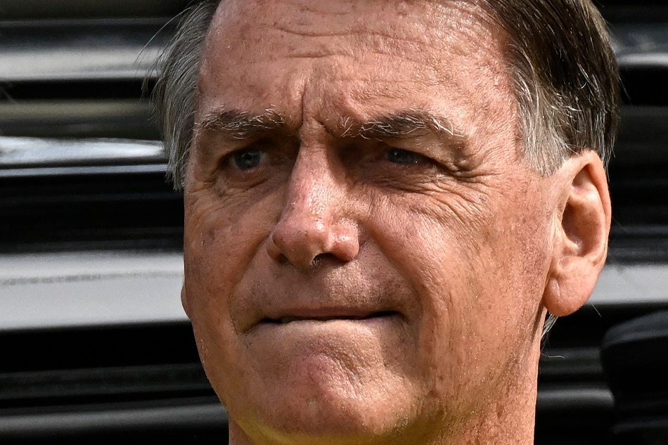 In this file photo taken on October 30, 2022, Brazilian President and re-election candidate Jair Bolsonaro arrives to vote at a polling station in Rio de Janeiro, Brazil, during the presidential run-off election. Brazil's former president Jair Bolsonaro, whose supporters attacked government buildings in Brasilia on January 8, is seeking a six-month visa to remain in the United States, a lawyer said January 30, 2023. MAURO PIMENTEL / AFP