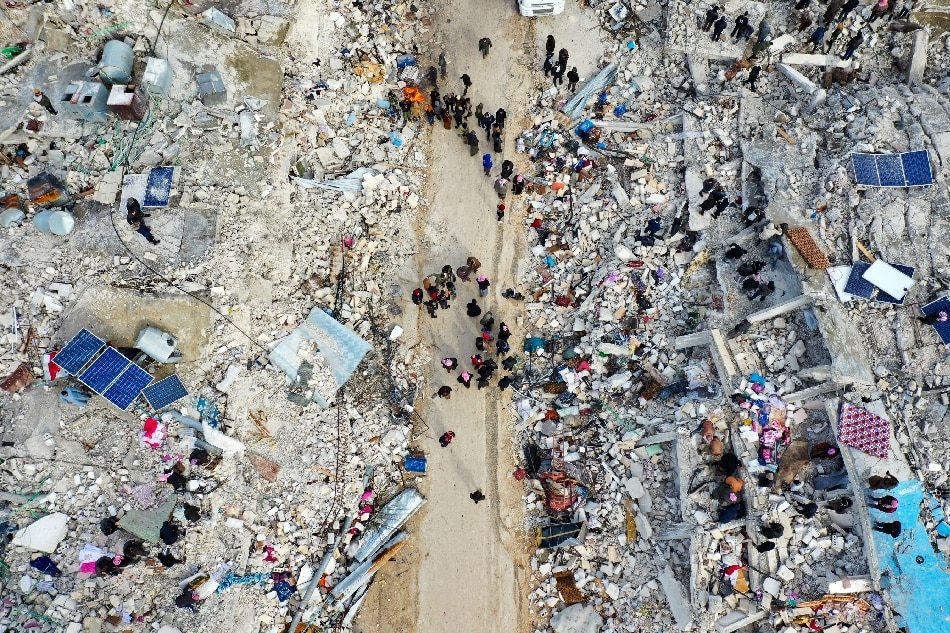 This aerial view shows residents searching for victims and survivors amidst the rubble of collapsed buildings following an earthquake in the village of Besnia near the twon of Harim, in Syria's rebel-held noryhwestern Idlib province on the border with Turkey, on February 6, 2022. Hundreds have been reportedly killed in north Syria after a 7.8-magnitude earthquake that originated in Turkey and was felt across neighbouring countries. Omar Haj Kadour / AFP