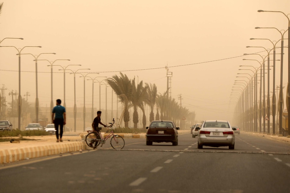 Cars drive along a street shrouded in heavy dust in west of Baghdad, Iraq, 16 May 2022. Ahmed Jalil, EPA-EFE/File photo.