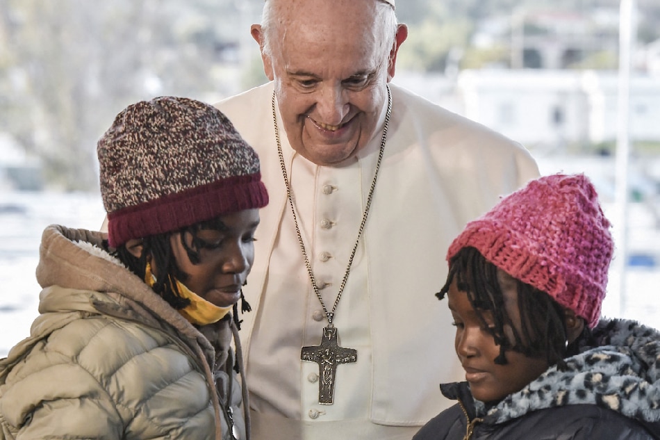 Pope Francis greets two young refugee girls at the Reception and Identification Centre (RIC) in Mytilene on the island of Lesbos on Dec. 5, 2021. Louisa Gouliamaki, Pool/AFP