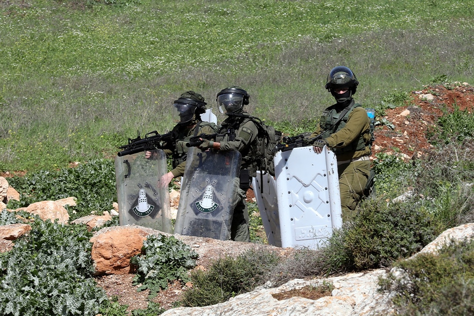 Israeli soldiers take positions as they stand guard during clashes with Palestinians after a protest at Bet Dajan village near the West Bank city of Nablus, March 17, 2023. Alaa Badarneh, EPA-EFE.