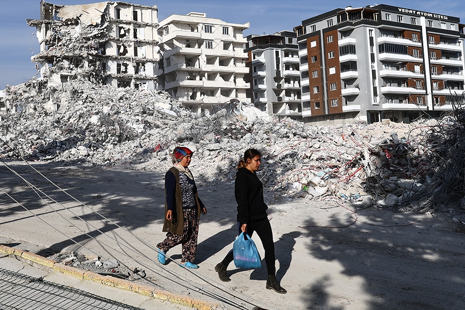 Two women walk by demolished buildings in Nurdagi district of Gaziantep, Turkey, 04 March 2023. More than 50,000 people died and thousands more were injured after major earthquakes struck southern Turkey and northern Syria on February 6 and again on February 20, 2023. Sedat Suna, EPA-EFE.