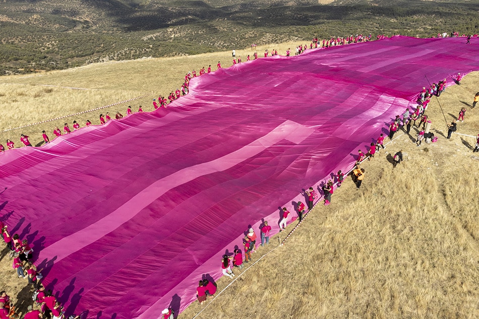 An aerial view taken from a drone of a pink ribbon of 25 meters by 275 meters placed by over 540 volunteers on the top of the twin mountain named 'Tetasde Viana' (literally, 'Viana's Tits') in Trillo town, Guadalajara province, central Spain, 08 October 2022. This initiative against breast cancer has broken the Guinness Largest Awareness Ribbon record. EPA-EFE/NACHO IZQUIERDO