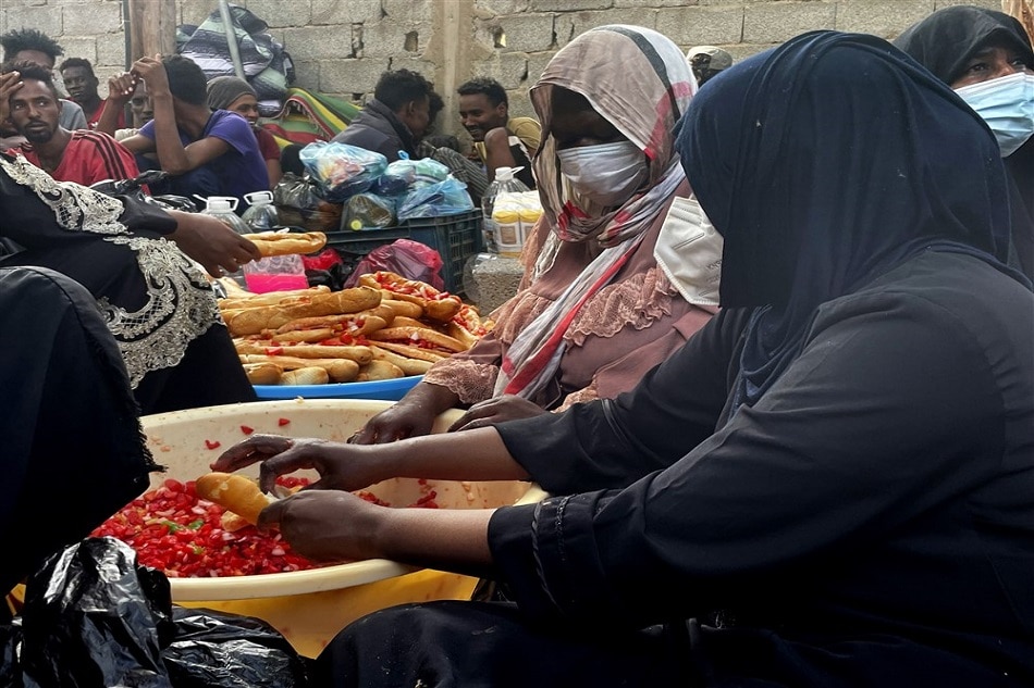 African migrants gather to cook their meal as they take part in a sit-in portest to demand that the internatinal community takes them out of Libya, outside the UNHRC office in Tripoli, Libya, on October 9, 2021. EPA-EFE/STR/file