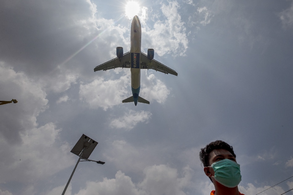 A man walks wearing face mask as a plane approaches to land in Tribhuvan International Airport Kathmandu, Nepal, 11 June 2020. EPA-EFE/NARENDRA SHRESTHA