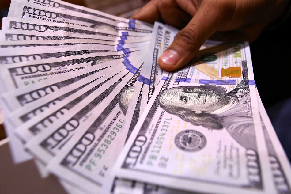 A foreign currency dealer counts US dollars at a money exchange company in Karachi, Pakistan, 27 January 2023. Shahzaib Akber, EPA-EFE.