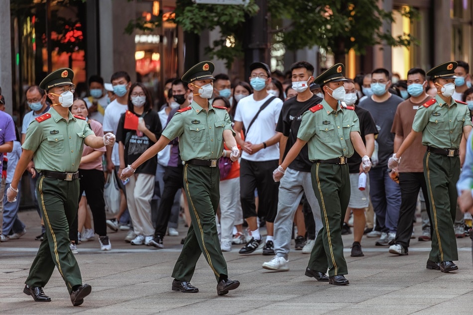 Army personnel secure a crosswalk in Nanjing pedestrian street while people are passing towards the Bund on China's National Day in Shanghai, China, 01 October 2022. Alex Plavevski, EPA-EFE