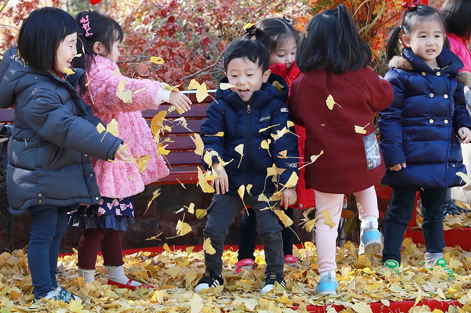 Children play with ginkgo leaves at Seokchon Lake in southern Seoul, South Korea, Nov. 2, 2018. EPA-EFE/Yonhap 