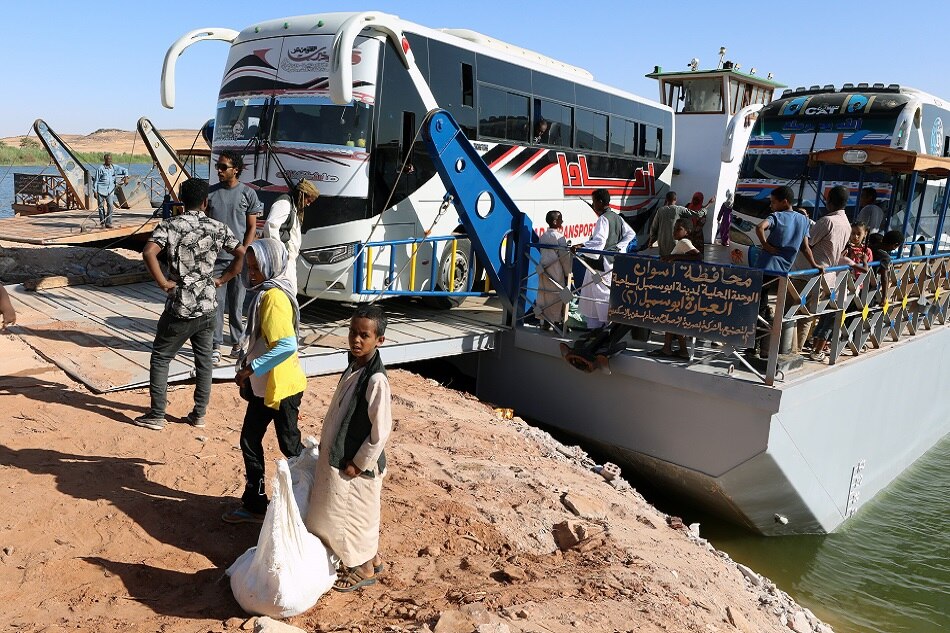 Buses carrying Sudanese people traverse the Nile River on a ferry after crossing the border from Sudan, in Abu Simbel, southern Egypt, May 20, 2023. The UN estimates some 200,000 people have fled Sudan since the conflict erupted. Khaled Elfiqi, EPA-EFE/File.