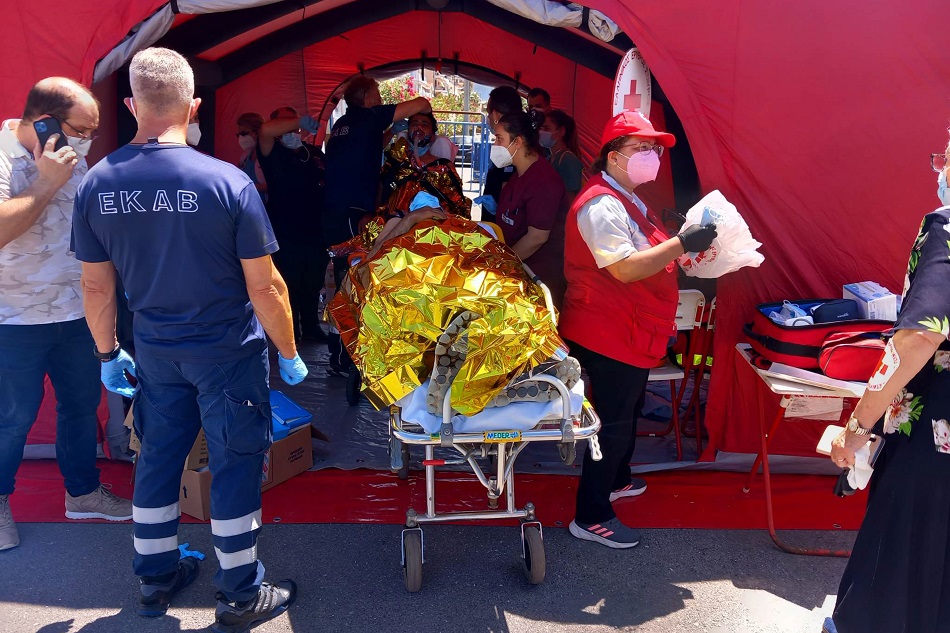 Paramedics of the Greek National Emergency Ambulance Service (EKAV) and members of the Greek Red Cross helps migrants upon arrival to the Kalamata
