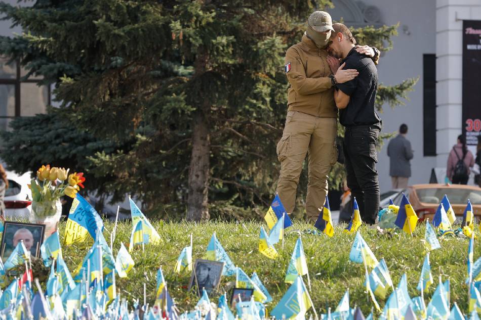 Two men embrace near the flags placed on Independence Square in commemoration of fallen Ukrainian soldiers, in downtown Kyiv, Ukraine, October 30, 2023 amid the Russian invasion. Russian troops entered Ukraine in February 2022 starting a conflict that has provoked destruction and a humanitarian crisis. Sergey Dolzhenko, EPA-EFE.