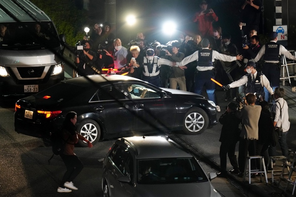 A police car carrying a suspected gunman who took hostages and barricaded himself is surrounded by photographers and TV cameramen as it arrives at a police station in Warabi City, Saitama Prefecture, Japan, on October 31, 2023. Kimimasa Mayaman, EPA-EFE